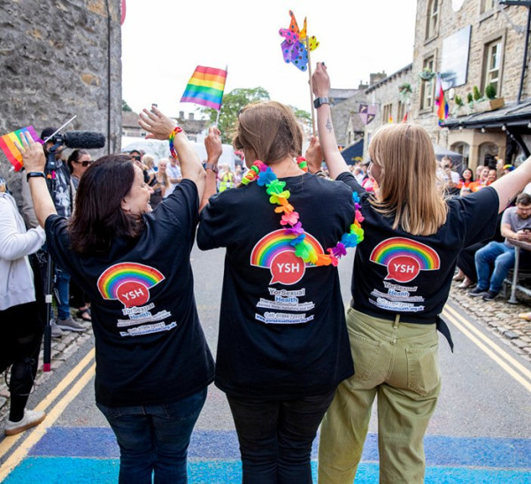 YorSexual Health staff turned away from the camera and waving in a pride parade