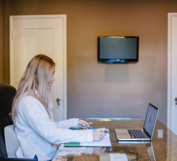 A woman smiling and using a laptop